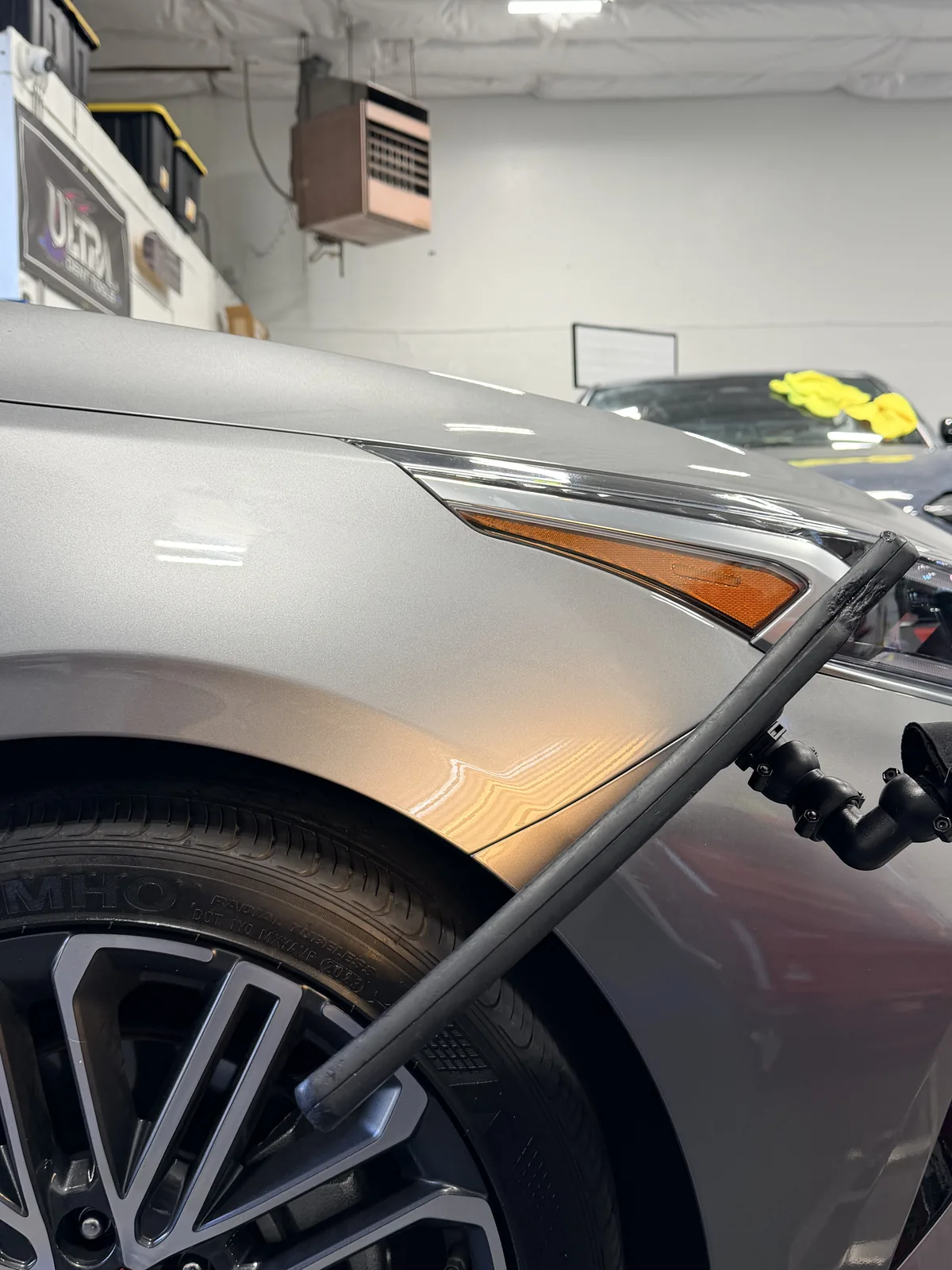 Same fender after paintless dent repair, reflection lines clean