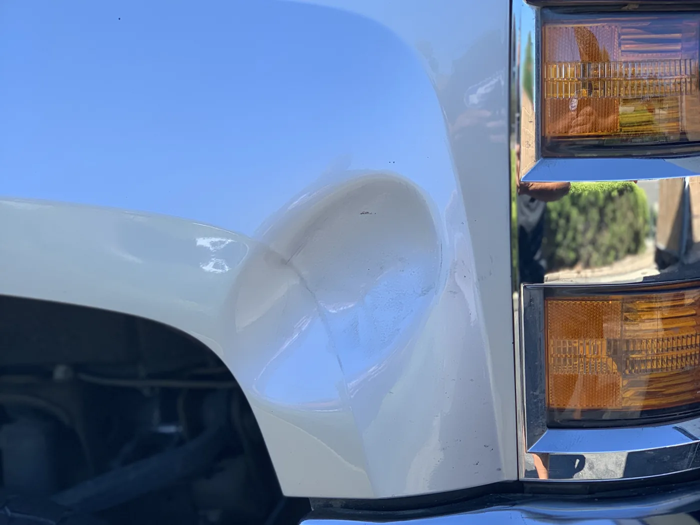 Truck fender with a deep dent before repair